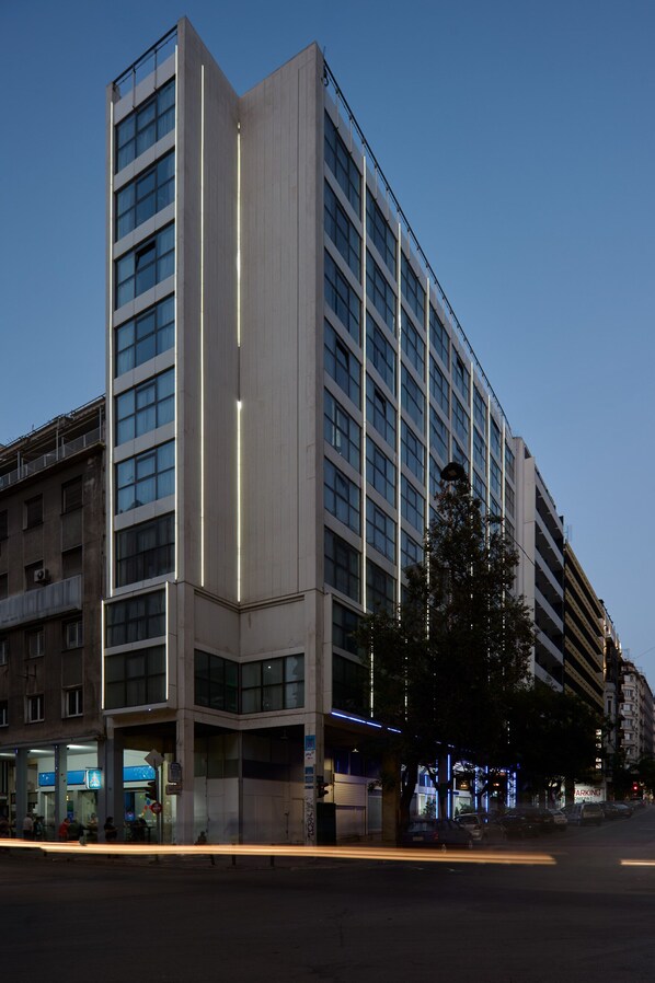 A multi-story hotel with a modern design, featuring a prominent vertical light strip on the facade.