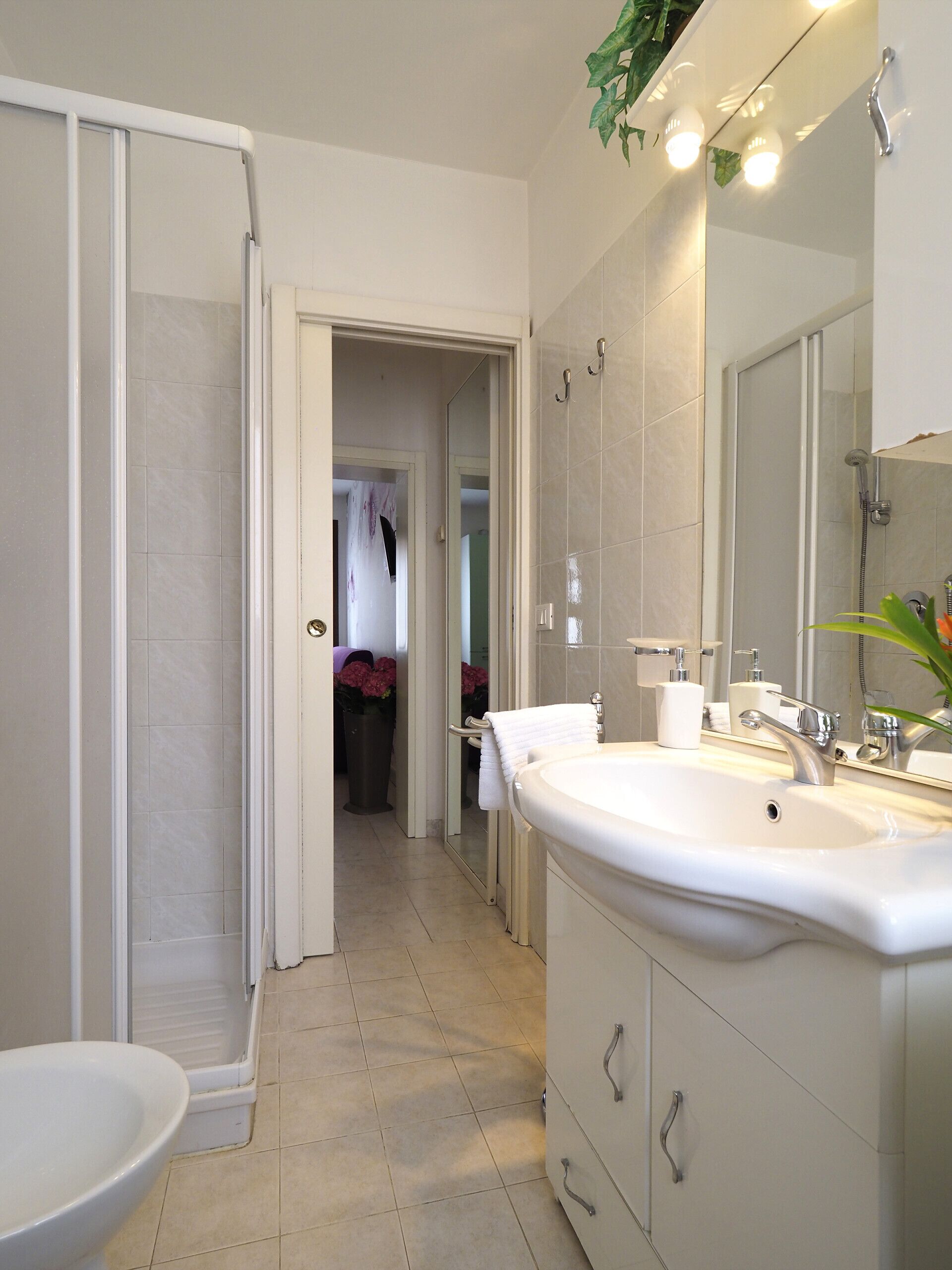 A modern bathroom with a shower, two sinks, and a large mirror.