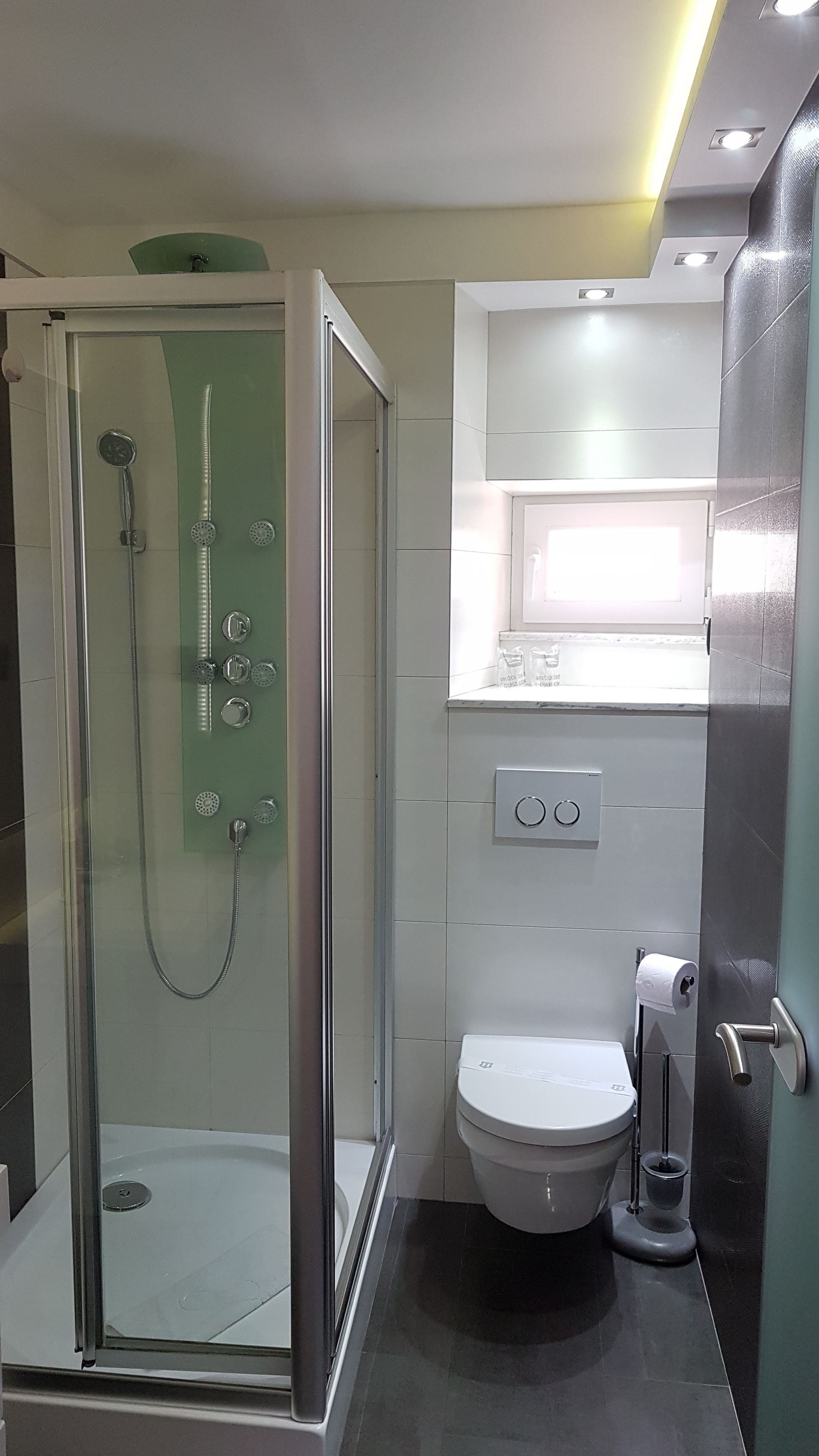 Un baño moderno con ducha de vidrio, inodoro y bidé.