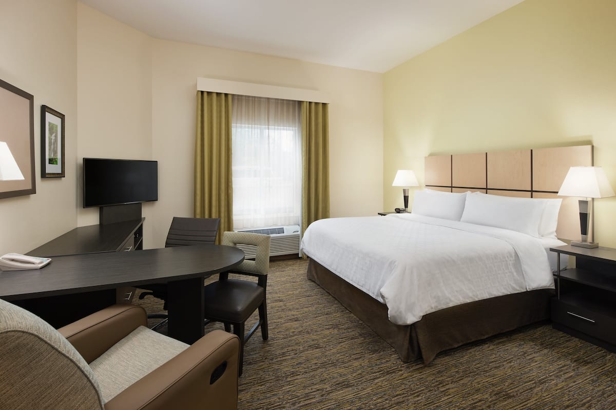 Une chambre d’hôtel équipée d’un lit, d’un bureau, de chaises et d’un téléviseur.