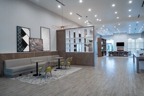 A modern interior with a sofa, chairs, a dining area, and a kitchen. - Holiday Inn & Suites Memphis Southeast-Germantown by IHG (Memphis)