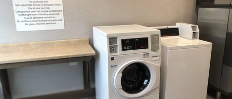A guest laundry area with a washing machine and dryer, a bench, and a sign with operating instructions.