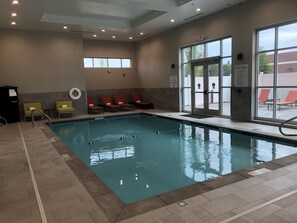 An indoor swimming pool with clear water, surrounded by lounge chairs and a poolside area. - Holiday Inn & Suites Memphis Southeast-Germantown by IHG (Memphis)