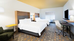 A hotel room with two beds, a desk, a chair, a TV, and a window. - Holiday Inn & Suites Memphis Southeast-Germantown by IHG (Memphis)