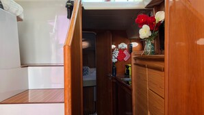 A compact kitchen with wooden cabinets, a small countertop, and a built-in oven. - Yacht Suite Castiglione della Pescaia (Castiglione della Pescaia)
