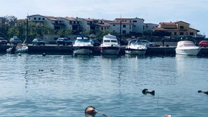A marina with several boats docked, a few cars parked nearby, and buildings in the background. - Yacht Suite Castiglione della Pescaia (Castiglione della Pescaia)