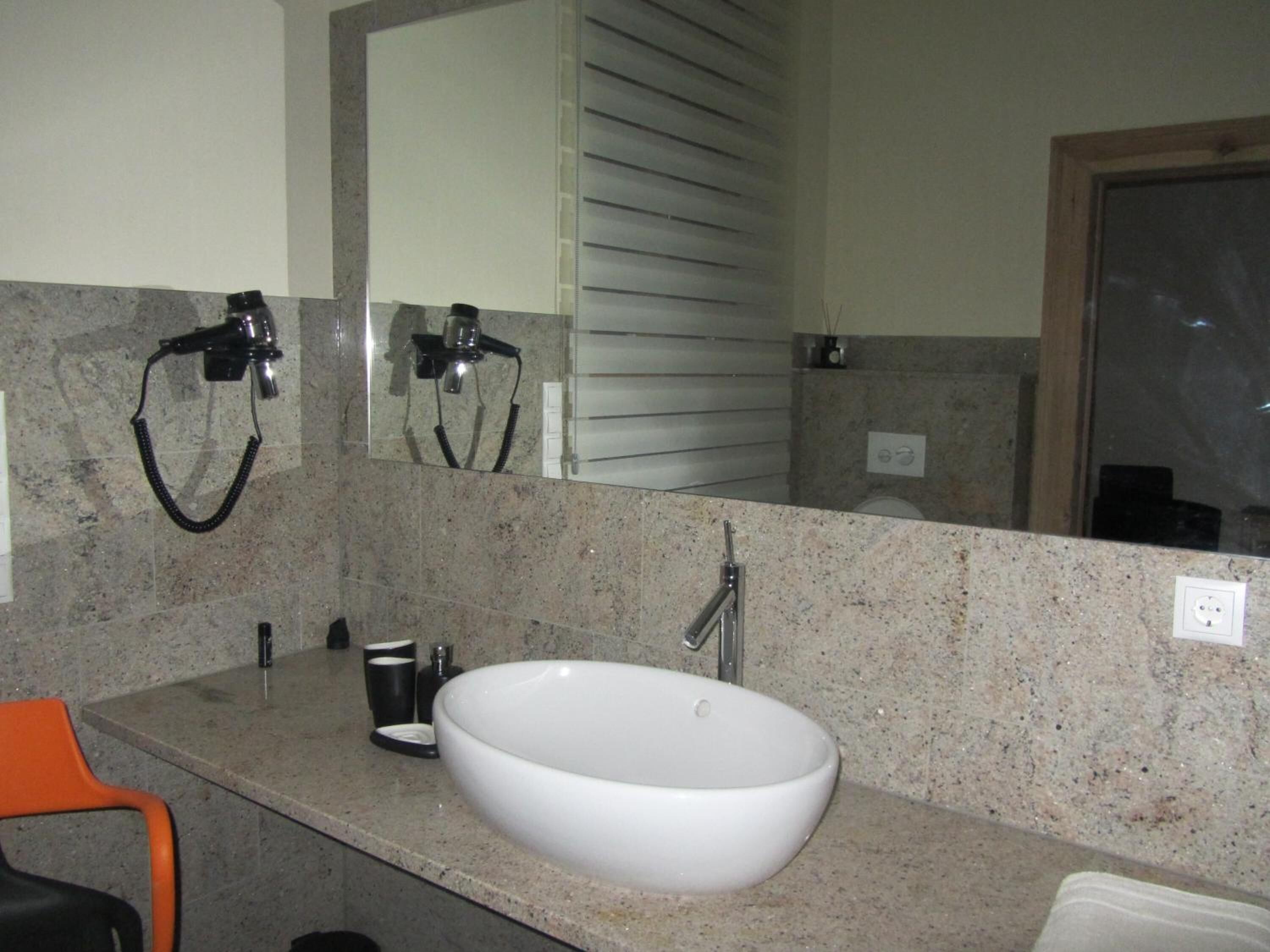 A bathroom with a white sink, a mirror, and a towel rack.