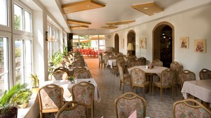 A spacious dining area with high ceilings and large windows, featuring tables and chairs arranged for dining. - Hotel Pappelhof (Weidenbach)
