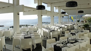 A restaurant with tables set for dining, overlooking the sea. - Hotel La Playa (Pollica)
