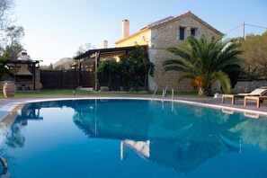 A swimming pool with a stone house in the background.