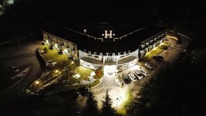A hotel named 'Theotokos' with a central entrance, multiple parking spaces, and a surrounding landscaped area. - Hotel Theotokos (Viggiano)