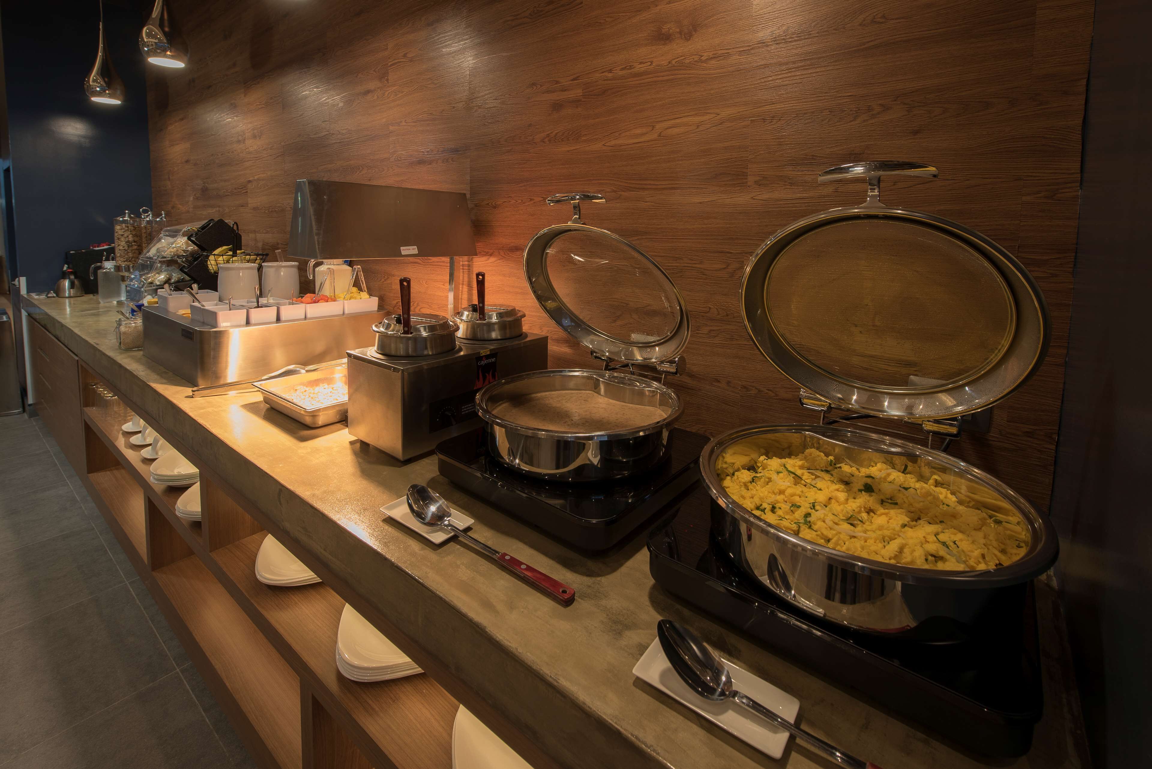 A buffet setup with various food items and serving utensils.