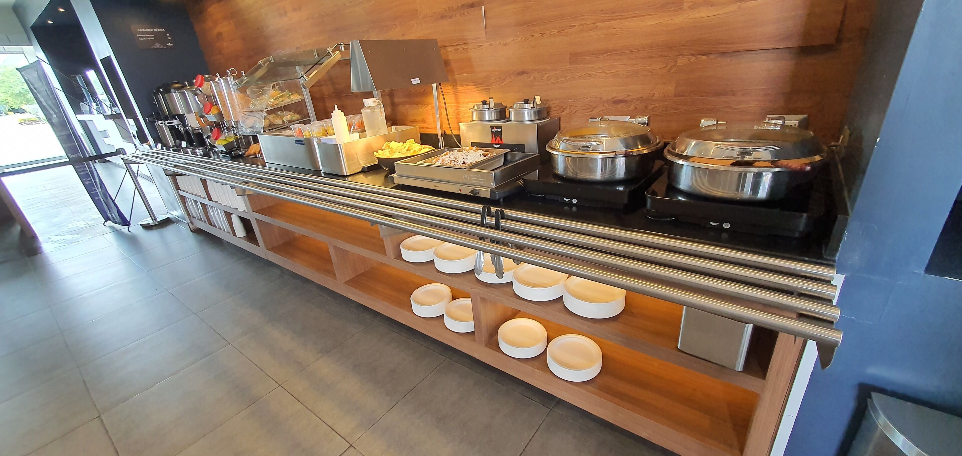 A buffet setup with various food items and containers, including a salad bar and hot dishes.