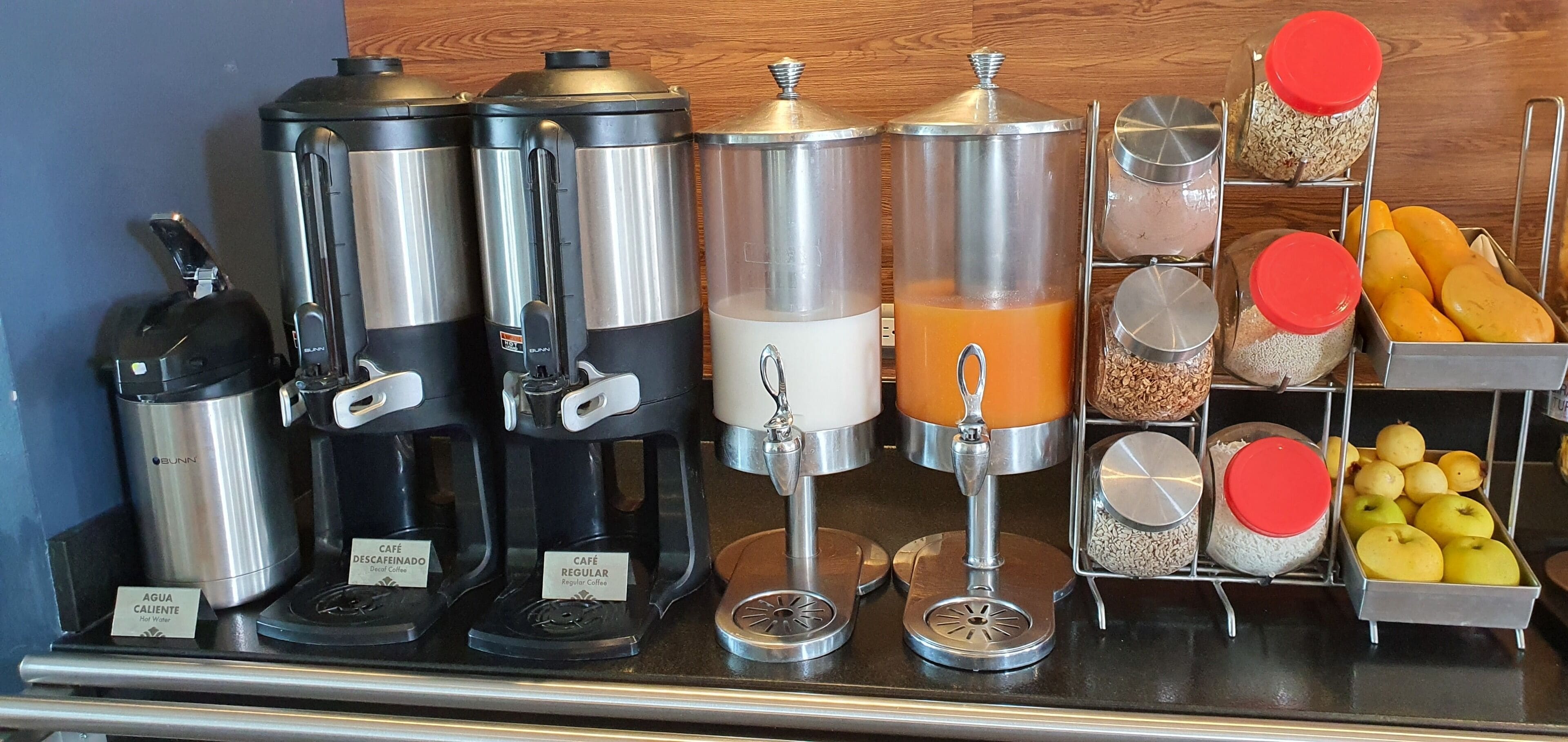 Eine Kaffeestation mit verschiedenen Spendern für heißes Wasser, entkoffeinierten Kaffee und regulären Kaffee.