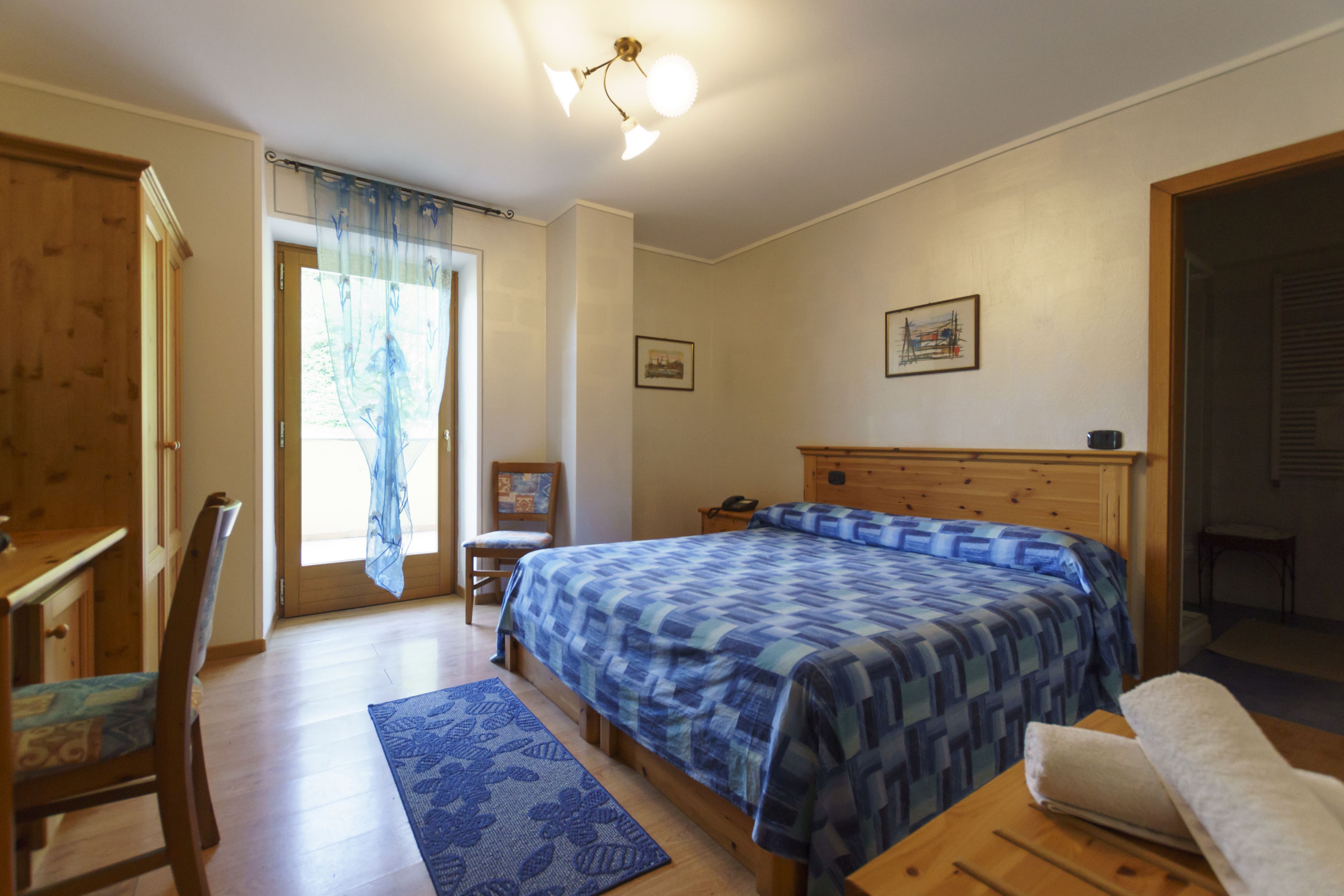 Ein Schlafzimmer mit einem hölzernen Bett, einem Schreibtisch und einem Stuhl.