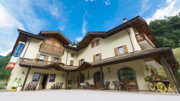 Ein zweistöckiges Gebäude mit Balkon, Außenbereich und einem Wagen.