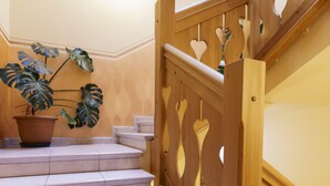 Eine Treppe mit hölzernen Geländern und einem Blumentopf auf der Zwischenebene.