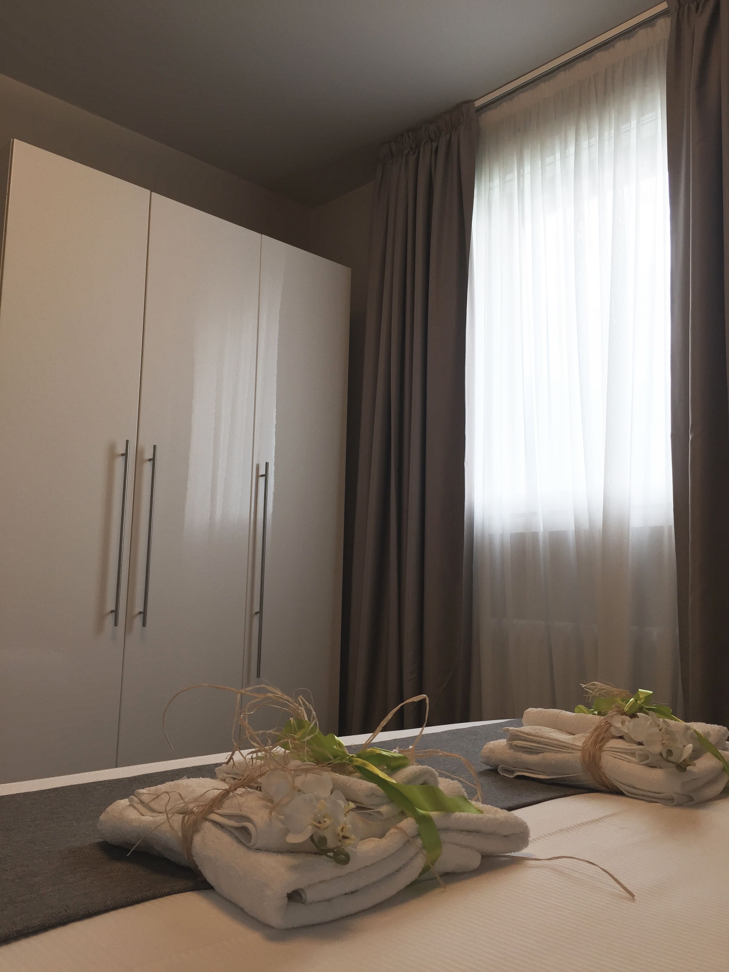 Ein Hotelzimmer mit einem Bett, einem Kleiderschrank und einem Fenster mit Vorhängen.