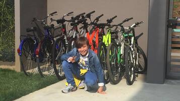 A person crouching in front of a row of bicycles.