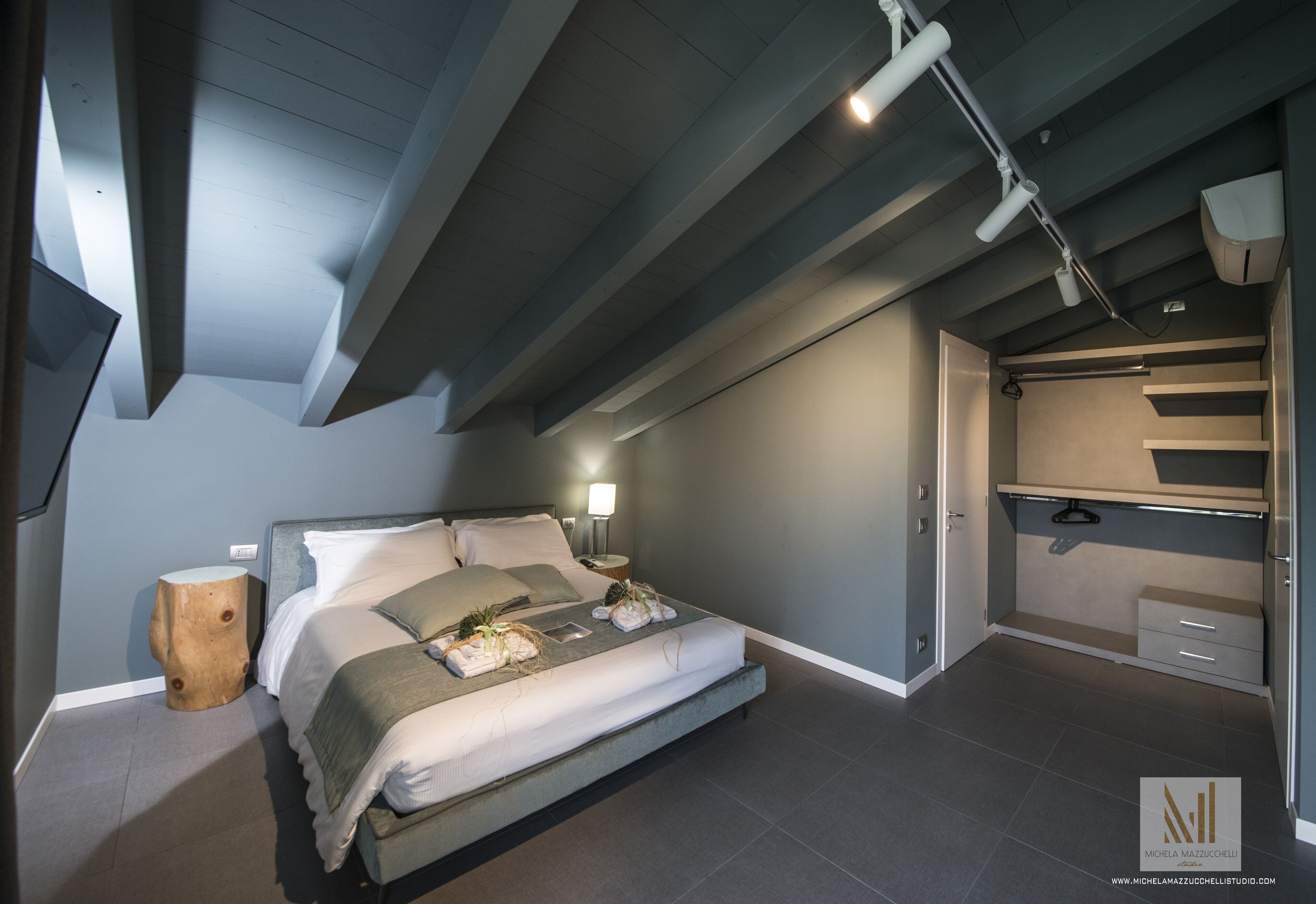 Un dormitorio moderno con cama, mesita de noche, lámpara y armario empotrado.