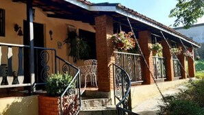 A two-story house with a balcony, a staircase, and a brick exterior. - Suites em Águas de São Pedro (Aguas de Sao Pedro)