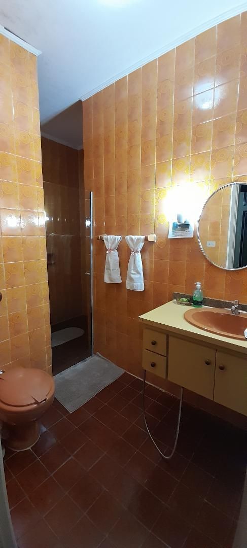 A bathroom with a toilet, sink, and shower.