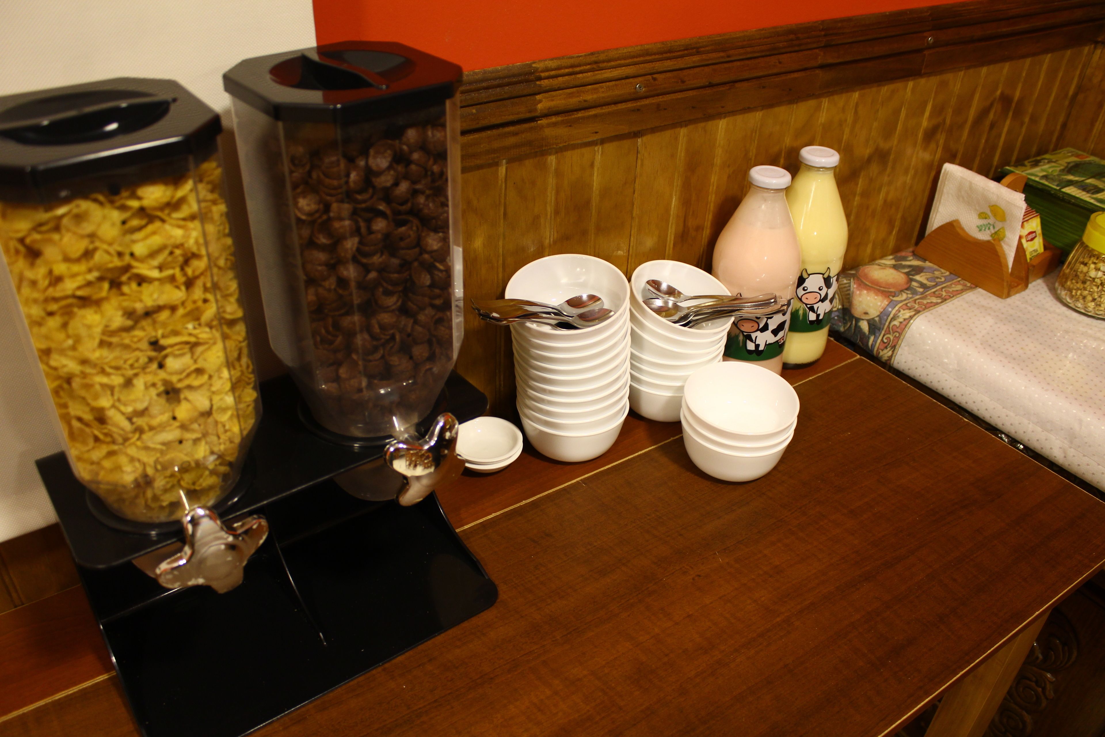A breakfast buffet setup with various food items and beverages.