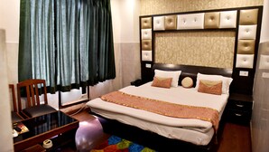 Habitación de hotel con una cama grande, una mesita de noche, una silla, un calentador y una ventana con cortinas.