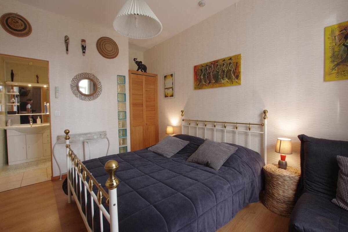 Een slaapkamer met een bed, nachtkastjes, een kledingkast en een spiegel.