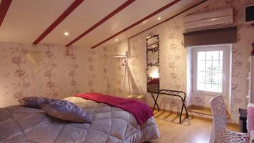 A bedroom with a bed, a chair, a mirror, and a window.