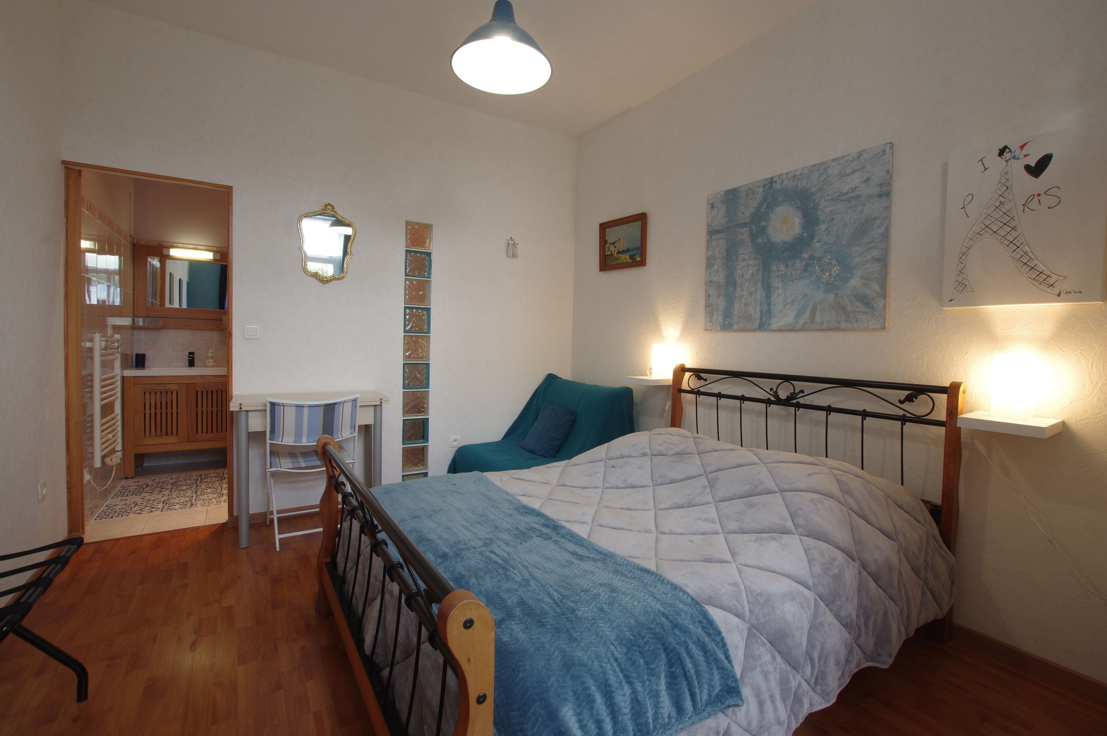Un dormitorio con cama, mesita de noche, silla y armario.