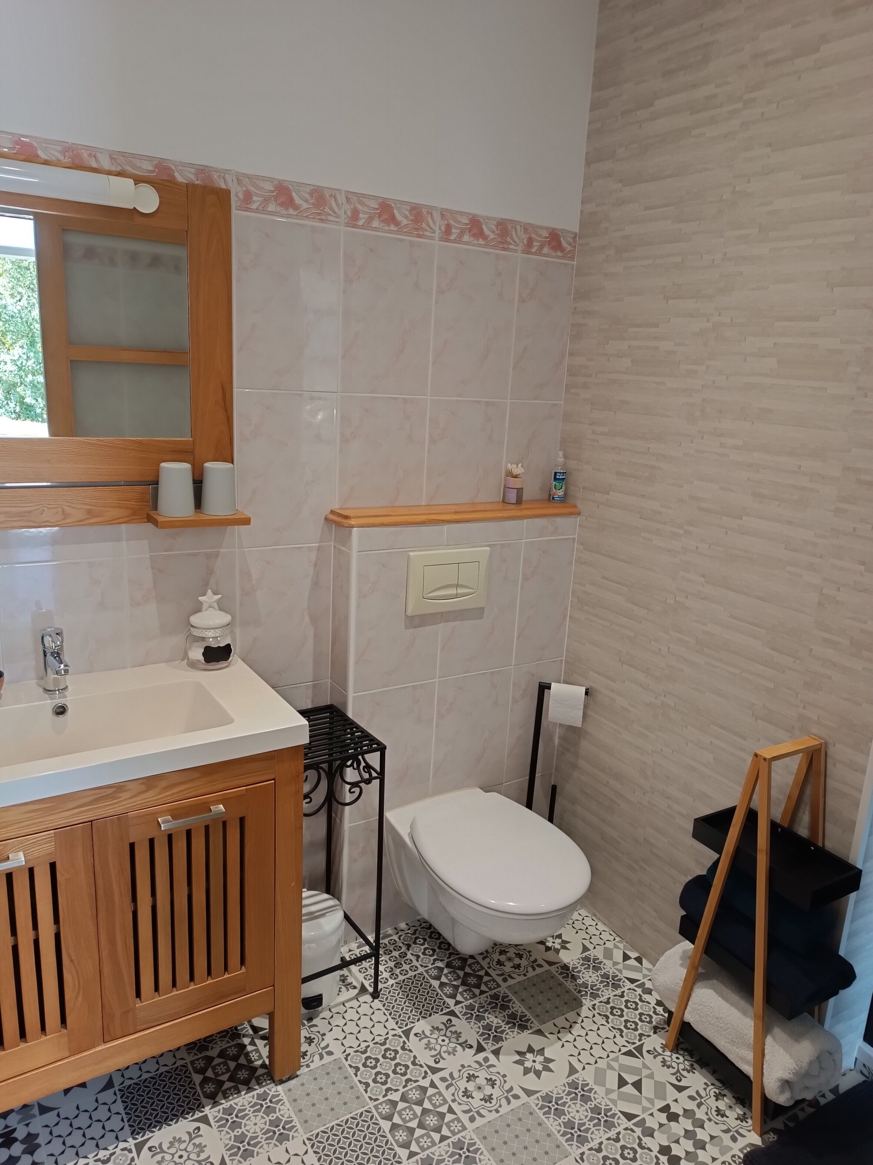 A bathroom with a wooden vanity, a sink, a toilet, and a shower area.