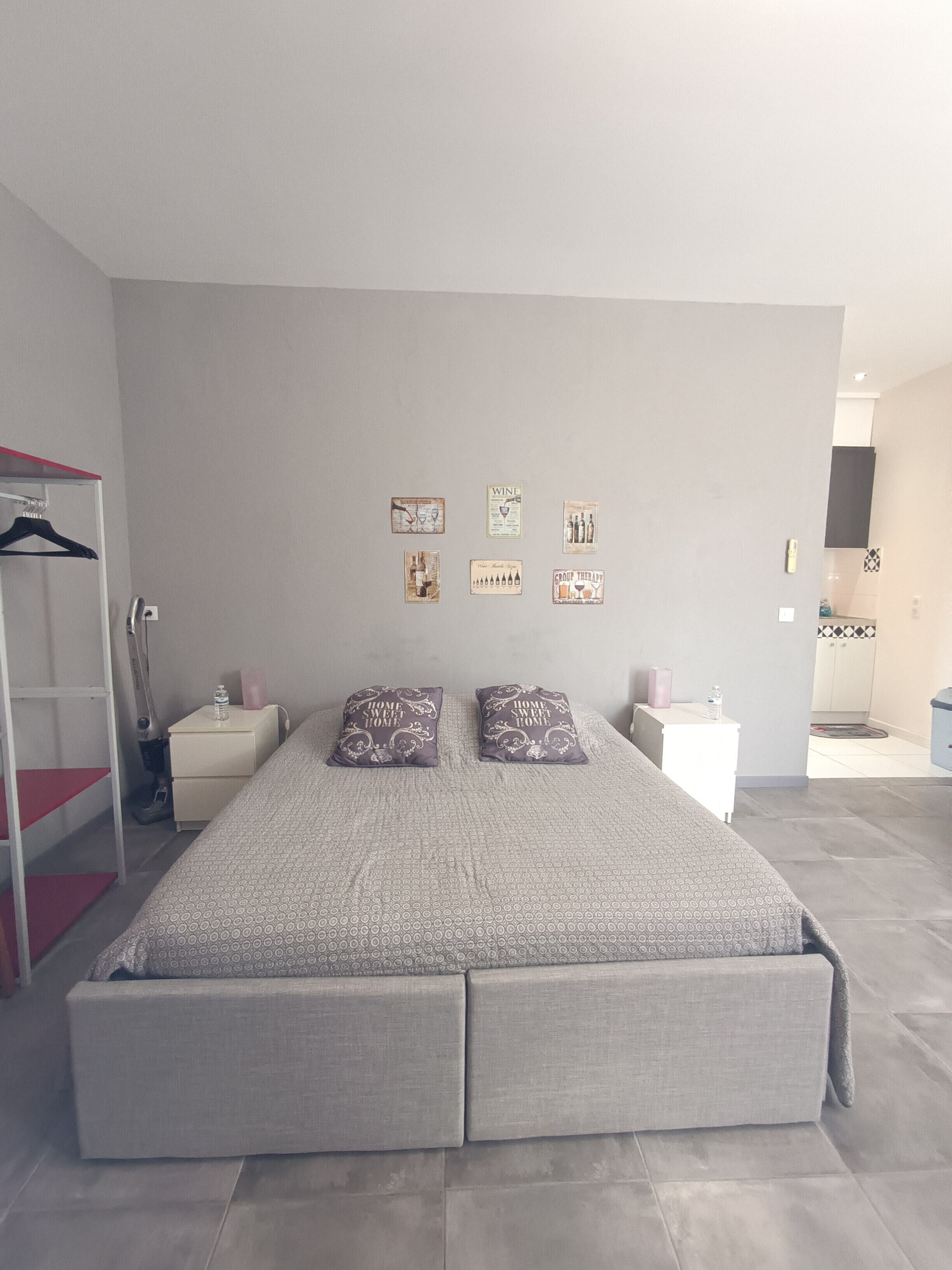 Un dormitorio moderno con una cama grande, un armario y una mesita de noche.