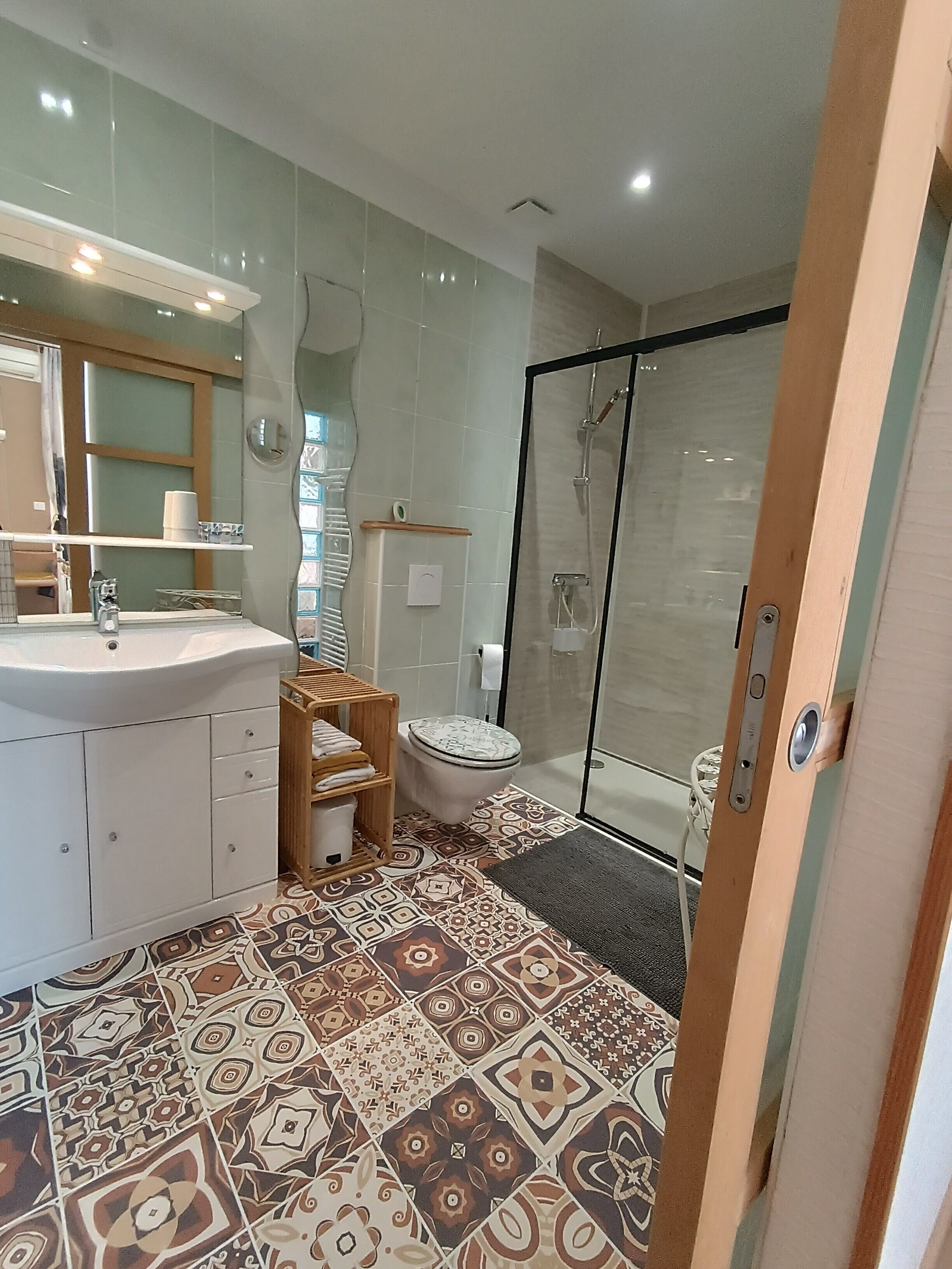 A modern bathroom with a large sink, toilet, and shower area.