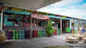 Un espace bar extérieur coloré, agrémenté d’une enseigne indiquant « Strandbar ».