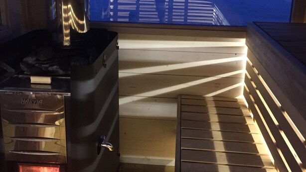 Un poêle à bois offrant une vue sur un plan d’eau au crépuscule.
