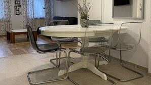 A dining area with a round table, four chairs, a potted plant, and a television mounted on the wall. - Fewo Reutlingen Metzstrasse (Reutlingen)