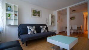 A modern living room with a sofa, a coffee table, and a bookshelf. - Fewo Reutlingen Metzstrasse (Reutlingen)