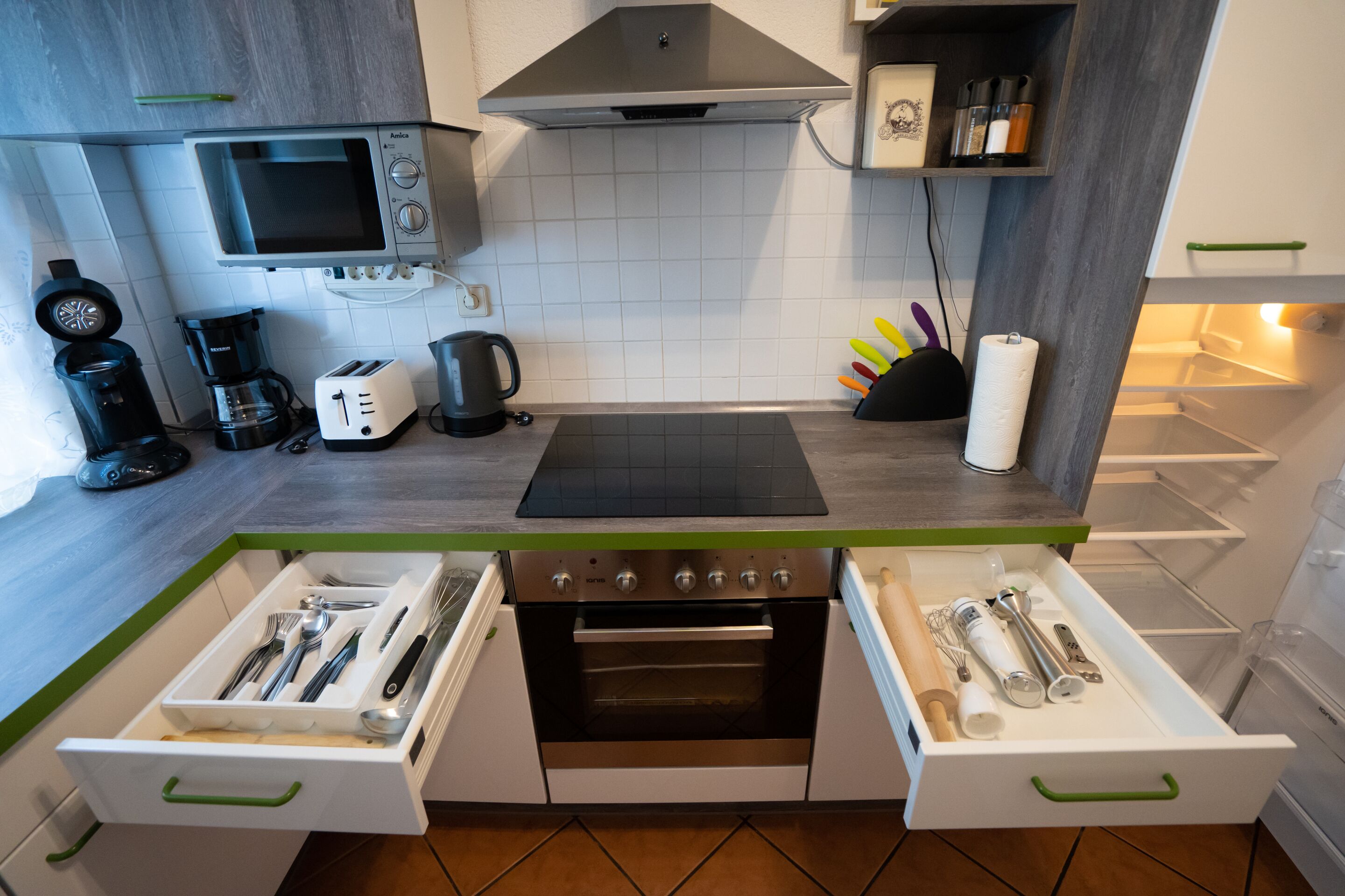 A modern kitchen with a built-in oven, a coffee maker, and a toaster.