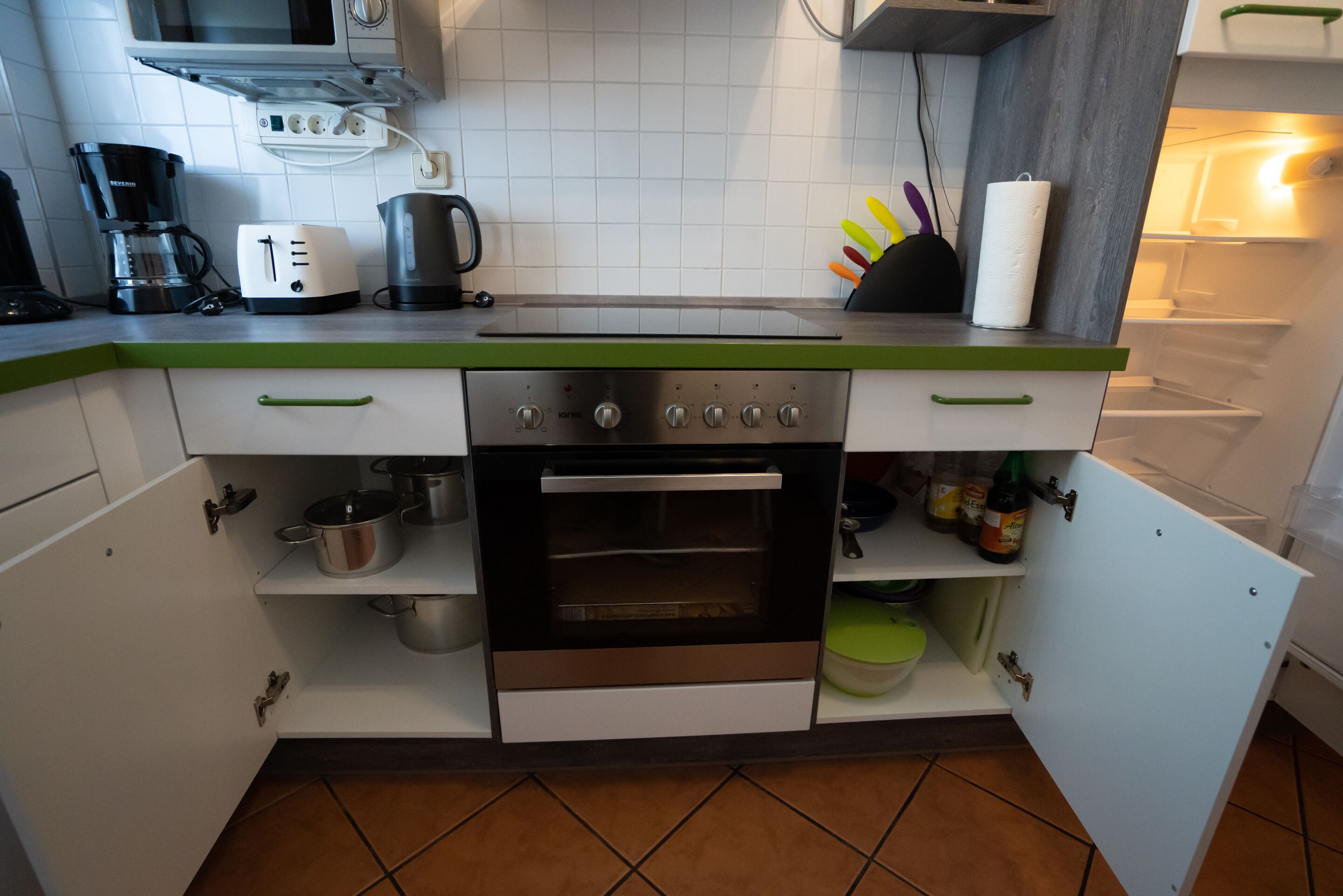A compact kitchen with a built-in oven, a coffee maker, and a toaster.