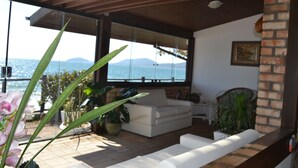 Una sala de estar moderna con un sofá blanco, una mesa de comedor y un amplio ventanal con vistas panorámicas.