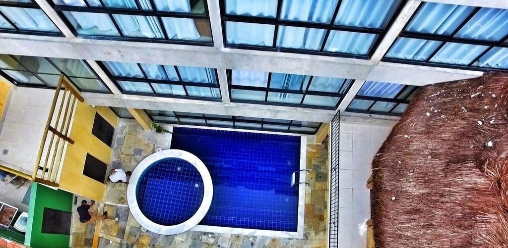 Una piscina al aire libre, sillones reclinables de piscina