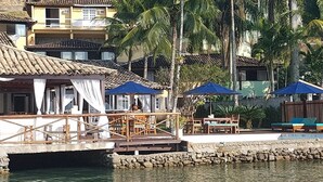 Une propriété située au bord de l’eau, dotée d’un espace repas, de sièges extérieurs et d’une piscine.