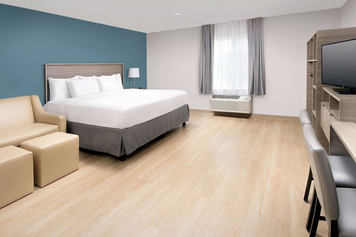 Une chambre d’hôtel équipée d’un lit, d’un canapé, d’une télévision et d’un appareil de climatisation.