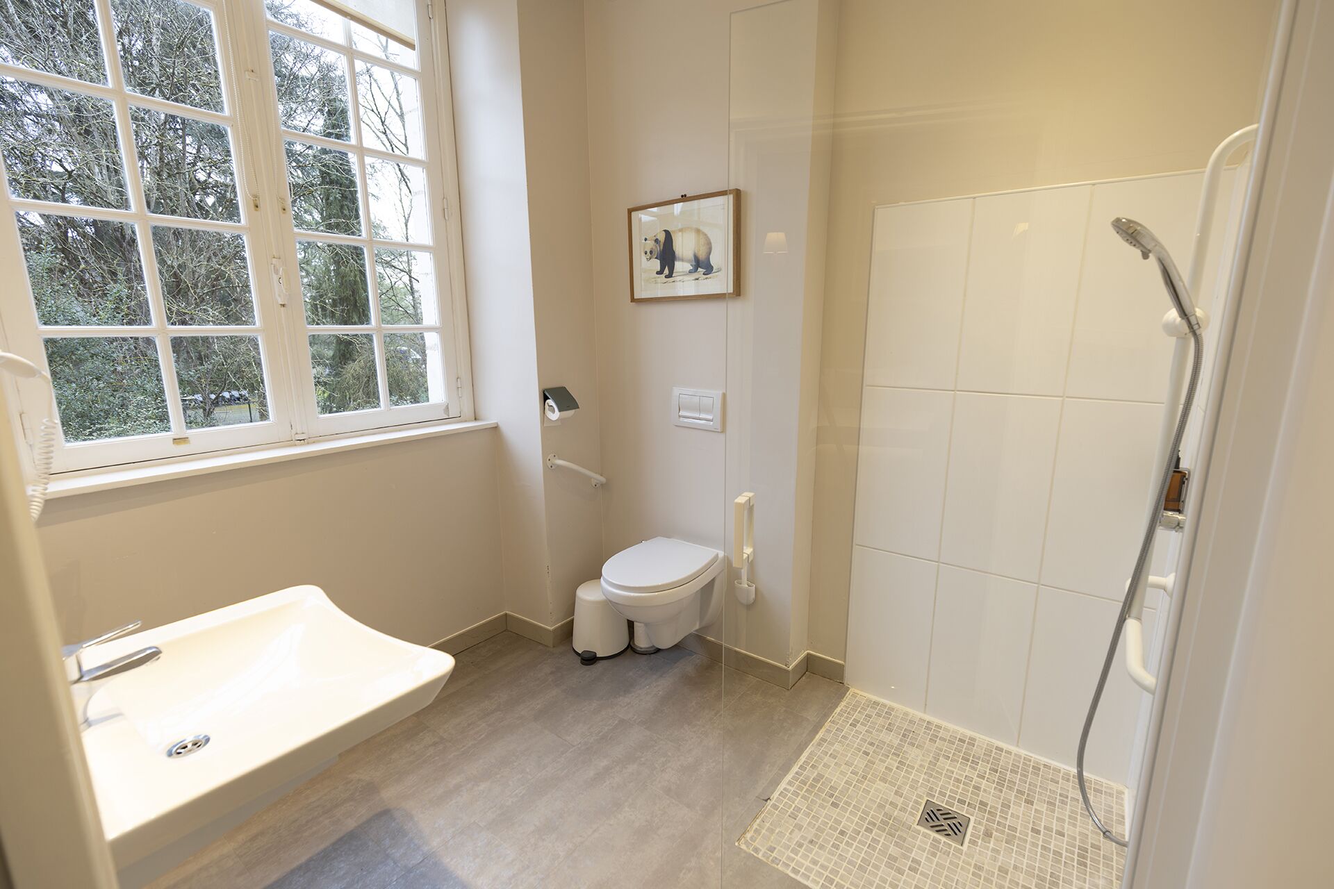 A bathroom with a toilet, sink, and shower.