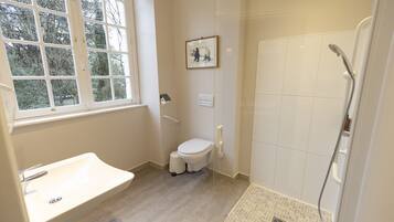 A bathroom with a toilet, sink, and shower.