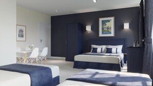 Een hotelkamer met twee bedden, een bureau en stoelen.