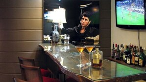 A bar area with a television displaying a sports event, a bottle of liquor, and a martini glass. - Sky Centro Hotel & Spa (Gramado)