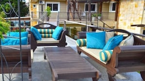 A patio area with wooden furniture, including sofas and a table, and a metal railing. - Sky Centro Hotel & Spa (Gramado)
