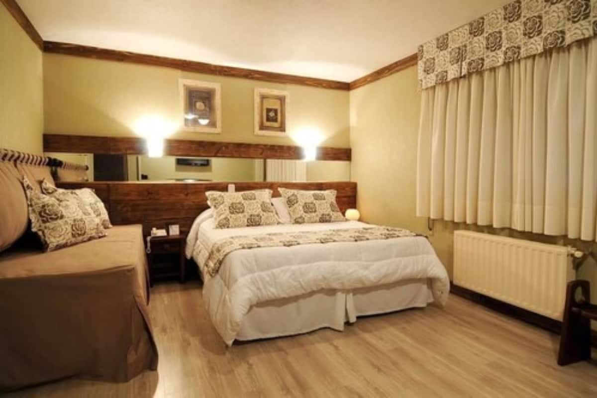 Un dormitorio con cama, mesita de noche, cómoda y ventana con persianas.